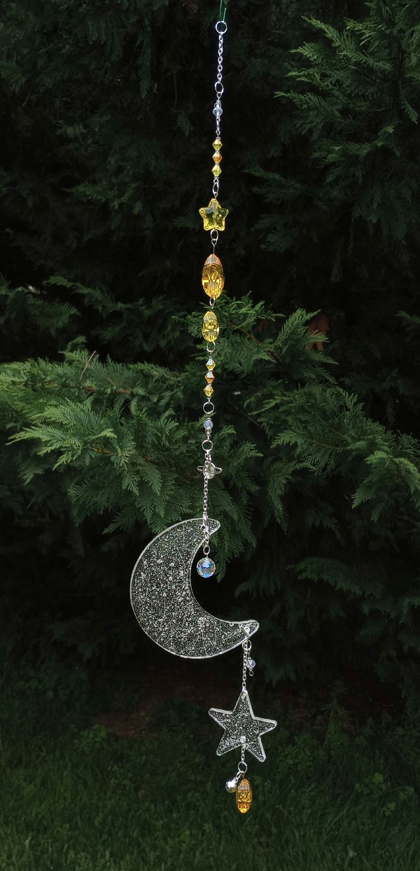 a long sun catcher with multiple yellow star beads, a large flat resin cresent moon, and a small flat resin star