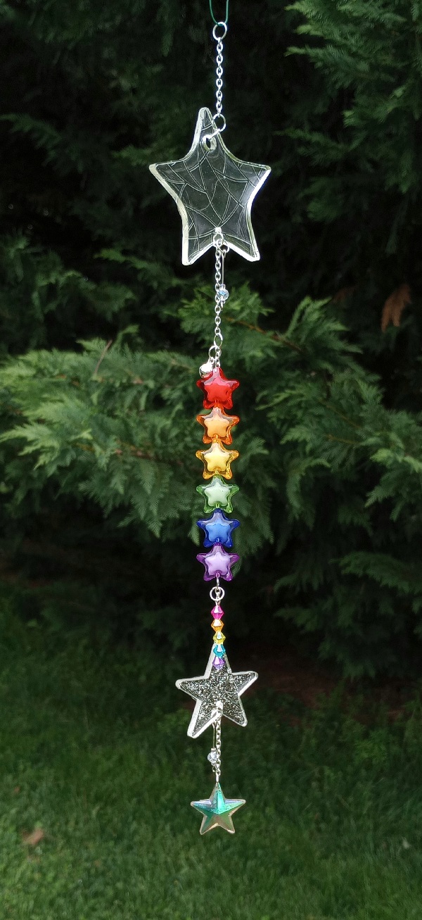 a star themed sun catcher with two resin stars and a rainbow string of star beads.