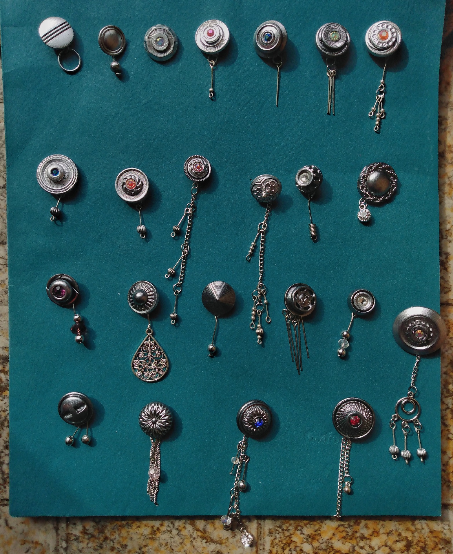 23 dangly earings displayed on a folder