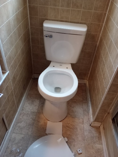 a white new toilet missing its lid