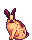 cream colored bunny sitting with brown splotches and freckles.
